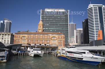 AUCKLAND NORTH ISLAND NEW ZEALAND May The rich red and tan colours of the sandstone and brick of the beautiful waterfront 1912 Ferry Building from Queens Wharf in Waitemata Harbour