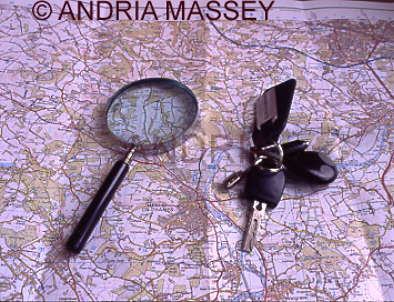 Magnifying glass and set of car keys on an ordnance survey map