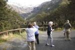 ARTHURS PASS CENTRAL SOUTH ISLAND NEW ZEALAND May Group of tourists photographing the snow covered Mount Rolleston from a roadside viewpoint