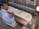 SARNATH UTTAR PRADESH INDIA November Man working at a loom making silk cloth