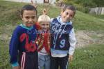 Transylvania Romania Europe September Three cheeky Romanian village boys two with dark hair flanking a blond boy giving the V sign 