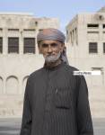 Dubai United Arab Emirates  Elderly Arab man wearing a dark pin striped Thobe and lilac and orange keffiyeh head dress